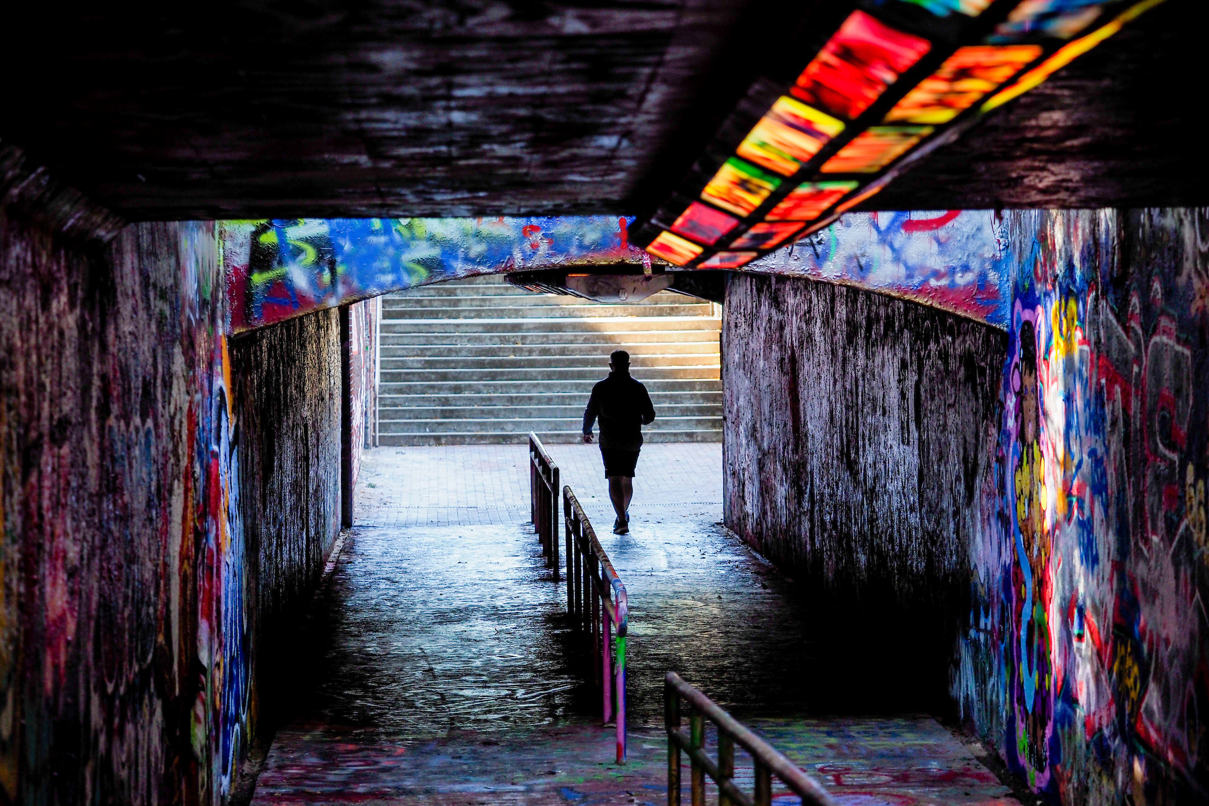A student walks towards the end of the Free Expression tunnel towards the light. 